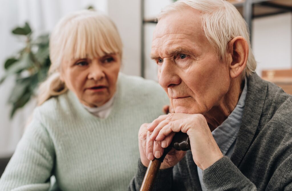 A woman sitting next to a senior citizen man who has dementia